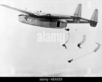 Parachutistes sautant d'un Fairchild C-82 'Paquet'. Il a été utilisé essentiellement pour le transport de fret et le transport de troupes, mais il a également été utilisé pour les opérations de parachutiste et de remorquage de planeurs. Sa capacité était de 41 parachutistes ou 34 brancards et il a clam-shell portes arrière qui permettait l'entrée facile de camions, de chars, d'artillerie, et d'autres marchandises volumineuses. Banque D'Images