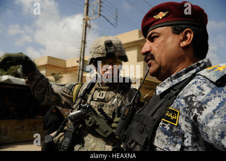 Le capitaine de l'armée américaine Eric Dunkley, Bravo Troop, 4e Escadron, 9e régiment de cavalerie, 2e Brigade, 1e Division de cavalerie, et le lieutenant-colonel de la police nationale irakienne de Mahmoud Salah, bataillon de police nationale de Mosul, discuter des procédures pour une mission dans le quartier de Tal Al Ruman de Mosul, Iraq, le 25 mars 2009. Banque D'Images