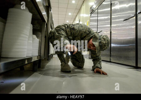 Airman Senior Jordan Hocker inspecte pour des ravageurs dans la salle à manger à la 379e escadre expéditionnaire aérienne en Asie du Sud-Ouest, 8 octobre 2013. Pest Management aviateurs, effectuer des inspections aléatoires à l'échelle de base pour garantir la qualité. Hocker est un 379e Escadron de génie civil expéditionnaire de compagnon de lutte déployés à partir de la Base aérienne de Ramstein, Allemagne et est originaire de Indianapolis. Tech. Le Sgt. Joselito Aribuabo) Banque D'Images