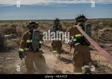 Les pompiers du 49e vol Protection incendie préparer pour contrôler la simulation d'un accident d'avion site au cours d'une accident massif de récupération à la base aérienne de Holloman, N.M., 19 février. Simulation de pompiers en prenant le contrôle de flammes d'un avion en feu tout en sécurisant les lieux pour d'autres premiers intervenants à entrer en toute sécurité. Navigant de première classe Aaron Montoya Banque D'Images