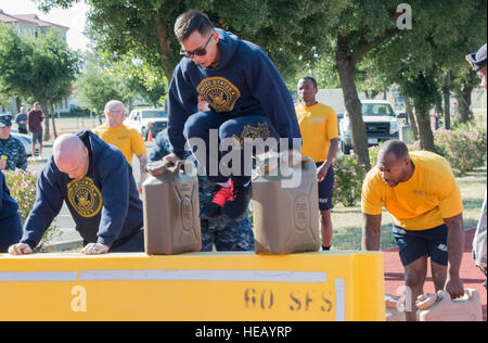 Au Maître de 3e classe d'armes Jacky Ng et MA3 Jordanie Frances, tous deux affectés à l'escadron de reconnaissance aérienne de la flotte (50-2106)3, U.S. Navy, de saut d'obstacles tout en portant des bidons pleins d'eau alors qu'ils prennent leurs cours à travers un obstacle tout en participant à un défi de remise en forme dans le cadre de la Semaine de la police, Travis Air Force Base, le 12 mai 2015. En 1962, le président John F. Kennedy a proclamé le 15 mai comme Journée de commémoration nationale des agents de la paix et de la semaine civile dans laquelle tombe le 15 mai, comme la Semaine nationale de la police. Créé par une résolution conjointe du Congrès en 1962, la Semaine nationale de la police porte une recognitio Banque D'Images