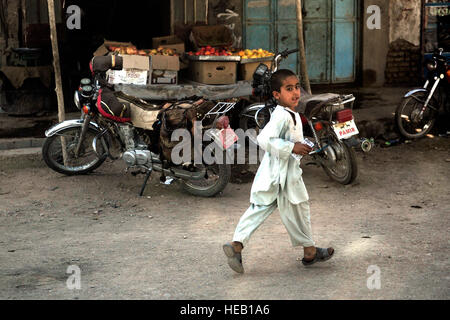 Un garçon afghan local court le long convoi de véhicules pendant une partie de l'Équipe de reconstruction provinciale à la mission Farah Directeur de l'information et de la Culture de la ville de Farah, dans la province de Farah, en Afghanistan, le 25 septembre. PRT Farah est une unité de soldats, marins et aviateurs canadiens travaillant avec divers organismes gouvernementaux et non gouvernementaux chargés de faciliter la gouvernance et la stabilité dans la région en travaillant main dans la main avec les autorités locales et le Gouvernement de la République islamique d'Afghanistan. Le but de l'ERP est de promouvoir le gouvernement afghan et leur capacité à résoudre les problèmes locaux et provi Banque D'Images