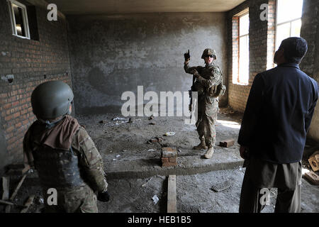 La province de Kunar, Afghanistan - Le Lieutenant de la Marine américaine j.g. Kimberly Herm demande que les spécifications du bâtiment le chef ingénieur de l'école au cours d'un projet Narang contrôle qualité 24 avril. Herm est une équipe provinciale de reconstruction d'ingénieurs du Kunar et aide le gouvernement afghan local sous la supervision de divers projets de construction dans la province. Le sergent Christopher Marasky Tech, PRT Kunar) Banque D'Images