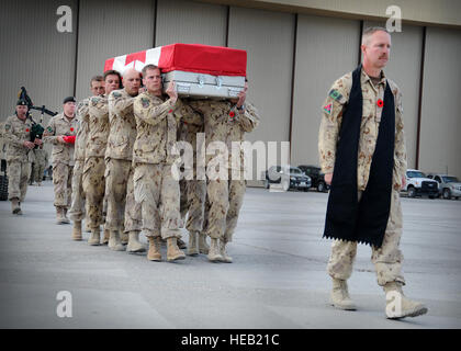 Un groupe de membres de services canadiens, dirigé par un aumônier, transporter la boîte de transfert de caporal-chef. Byron Greff, 3e Bataillon, Princess Patricia's Canadian Light Infantry, à un C-130 sur l'air de Bagram terrain au cours d'une cérémonie le 31 octobre. Greff a été tué dans une attaque des Taliban le 29 octobre lorsqu'un véhicule bourré d'explosifs a foncé dans le passager blindés Rhino Greff voyageait dans. Greff a servi comme une mission de formation et de conseiller en développement, formateur de formateurs pour sensibiliser les membres de l'Armée afghane. Environ 920 membres des Forces canadiennes servent dans des rôles de conseil et de soutien à des camps d'entraînement Banque D'Images