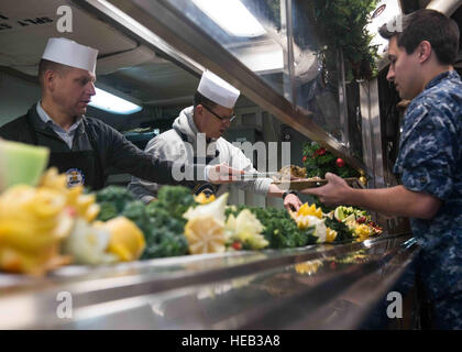 151225-N-KM956-067 BREMERTON Washington (déc. 25, 2015) -Capt Mike Wettlaufer, USS JOHN C. STENNIS (CVN 74) Commandant, Commandement et Master Chief Trenton Schmidt servir l'électronique d'aviation 2ème classe technicien Isaac Espada, de Costa Mesa, Californie, dans l'office arrière lors de Stennis' repas de vacances. L'équipage de Stennis est en ce moment à port la formation de futurs déploiements. Spécialiste de la communication de masse 3 Classe Aime Lykins / relâché) Banque D'Images