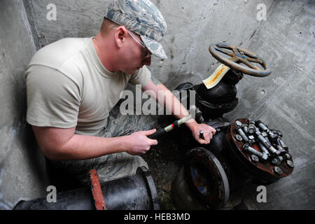 Les cadres supérieurs de l'US Air Force Airman Joseph LaGrow, 354e Escadron de génie civil de l'usine de traitement des eaux usées, l'exploitant remplace un robinet-vanne à l'usine de traitement des déchets le 20 juillet 2012, Eielson Air Force Base, en Alaska. La vanne d'égout permet de circuler dans les lits de séchage pour faciliter la transformation en engrais. Le s.. Jim Araos) Banque D'Images