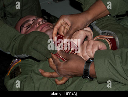 SCOTT AIR FORCE BASE, dans l'Illinois -- Personnel des sergents. Kamesha Lewis et Douglas Sanchez, 375e Escadron d'évacuation aéromédicale Aeromedical Evacuation des techniciens, limiter le personnel de l'Armée de Sgt. Erick Pisauro, U.S. Army Institute de recherche chirurgicale de l'unité de gravure, technicien en vol au cours d'un exercice d'urgence psychiatrique sur un KC-135 Stratotanker de Altus AFB, en Oklahoma, le 29 août 2012. Pendant le vol les deux unités pratiqué scénarios médicaux qu'ils sont susceptibles de faire l'expérience durant des missions. Navigant de première classe Kenneth W. NORMAN / Libre / 97e Escadre La mobilité de l'Air Affaires publiques) Banque D'Images