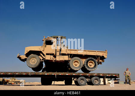 Airman Senior Hunter Spears dirige l'Aviateur Senior Shane Zimmerman en position comme il place un U.S. Army M939 5-Ton véhicule sur une remorque pour le transport à Al Udeid Air Base, au Qatar, le 17 janvier 2014. Le 379e Escadron de préparation logistique expéditionnaire avait été chargé d'aller de 51 véhicules et autres pièces d'équipement de l'ancien 11e Brigade d'artillerie de défense aérienne, 1er Bataillon, 43e Régiment d'artillerie de défense aérienne, site d'un point de collecte pour une distribution ultérieure. Tous les véhicules ont été inutilisable et a dû être remorquée ou chargés sur une remorque à plateau pour le mouvement. C'était le dernier effort en t Banque D'Images