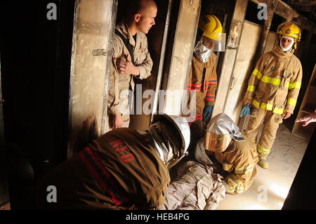 ALI, BASE DE L'Iraq - Senior Airman Nicolas Gagnon, 407e Escadron de génie civil de la Force expéditionnaire du service d'incendie, les pompiers irakiens locaux observe qu'elles extraient une maquette victime d'un bâtiment au cours de "recherche et sauvetage" formation le 23 mars. Les membres du 407e éducatrices en formation pratique pour les pompiers de l'Iraq pour aider à accroître leurs compétences. Airman Gagnon est déployée à Ali de la 366e Escadron de génie civil à Mountain Home AFB, ID et est originaire de Tampa, FL. Le s.. Christopher Marasky) Banque D'Images