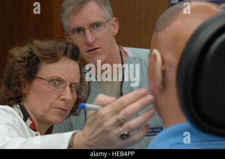 Médecin Nancy Hansen, à gauche, le seul panneau certifié anaplastologist clinique dans le département de la Défense, et de la Force aérienne Le Colonel Alan Sutton, prothèses maxillofaciales, directeur du programme de bourses de monter l'armée à la retraite pour des raisons médicales le s.. Shilo Harris avec modèles de cire de prothèses oreilles lors d MacKowan Clinique Dentaire sur Lackland Air Force Base, Texas, 5 octobre 2010. Harris a été blessé à Bagdad, Iraq, févr. 2007. Le s.. Robert Barnett, U.S. Air Force Banque D'Images