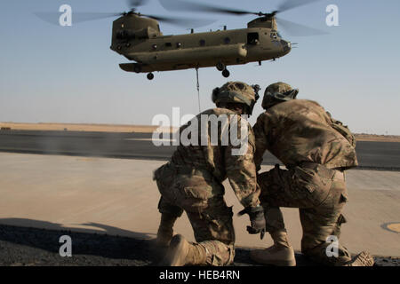 Les soldats de la 526e Bataillon de soutien de la Brigade, 2e Brigade Combat Team, 101st Airborne Division (Air Assault) attendre une 40e Brigade d'aviation de combat d'hélicoptère Chinook pour survoler leur cargo le 11 août au Camp Buehring, le Koweït. Les unités ont été la formation sur la charge sous élingue de mouvements, une partie essentielle de l'armée américaine la capacité centrale pour déplacer l'équipement dans la zone d'opérations au Moyen-Orient. Le Sgt. Brandon Hubbard, USARCENT) Affaires publiques Banque D'Images