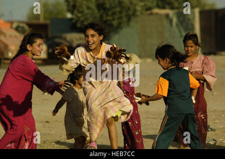 Une jeune fille iraquienne dans Multaka, sauts de joie l'Iraq après avoir reçu des jouets, d'un soldat américain, 1er Bataillon-87e Régiment d'infanterie, 10e division de montagne, Fort Drum, N.Y., 19 juin 2008. Le s.. I. Ave Pele-Sizelove Banque D'Images