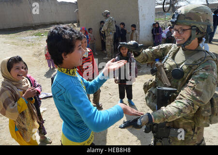 Le s.. Elizabeth Rosato, membre du 755e Escadron des Forces de sécurité de la Force expéditionnaire du Canada Équipe de Reaper 1, rencontre avec les enfants des écoles locales afghanes à l'extérieur du champ de l'air de Bagram, en Afghanistan, le 11 mars 2013. Le moissonneur équipe effectue des patrouilles près de Bagram Air Field pour la lutte contre les engins explosifs improvisés et les attaques de tir indirect, et à s'impliquer dans la protection de l'appui des gens de la base. Chris Willis) Senior Airman Banque D'Images