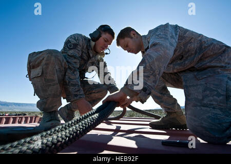 Les aviateurs de l'US Air Force, 820e Escadron Cheval Rouge vol aéroporté, prendre un genou comme un CH-47 Chinook, Army National Guard, Stockton, CA, récupère une partie d'un aéronef au cours d'une opération de paix, le 9 novembre 2011, dans le sud du Nevada, la charge de la formation et de la certification d'assaut aérien de RHS 820e vol aéroporté aviateurs s'est révélé crucial dans le succès de l'opération d'intervention rapide. Un membre de la 1re classe Daniel Hughes Banque D'Images