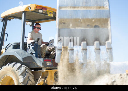 Un technicien des chaussées et de l'équipement du 455e Escadron expéditionnaire du génie civil exploite une pelleteuse à l'aérodrome de Bagram, en Afghanistan, préparant la zone au ciment pour soutenir un projet de construction d'entretien de grande superficie. Banque D'Images