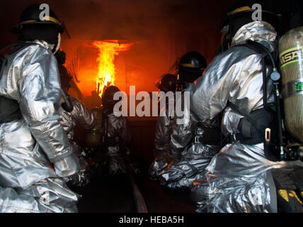 ALTUS AIR FORCE BASE, en Oklahoma - Stacy Belk, de l'Université Oklahoma State fire service instructeur de formation, montre les membres du 97e Escadron de génie civile service d'incendie si à pulvériser de l'eau au cours d'un exercice incendie flashover mine à la base de la formation, le 28 août 2012. Au cours de la formation, les pompiers ont appris des façons d'éteindre un feu flashover avant qu'elle ne se produise, ce qui leur donne suffisamment de temps pour s'échapper. Navigant de première classe Kenneth W. NORMAN / Libre / 97e Escadre La mobilité de l'Air Affaires publiques) Banque D'Images