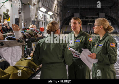 Air Force Reserve Maj. Shana Weber (centre), une infirmière de vol avec le 746e Escadron d'évacuation aéromédicale ici at Joint Base Lewis-McChord, va sur un scénario de formation avec les membres de son équipe sur un champ de McChord C-17 Globemaster III au cours de l'avion de transport en vol de l'unité de formation médicale, le 21 janvier 2015. Les 2 100 hommes et femmes affectés à l'aide AW 746e l'Air Mobility Command (AMC) mission à travers le monde sur une base quotidienne, l'exécution de 44 pour cent de toutes les missions laissant JBLM C-17. (U.S. Air Force Reserve Jake Chappelle) Banque D'Images