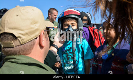 Le lieutenant-colonel Greg Pohoski (extrême gauche), un pilote de chasse affectés à la Garde nationale aérienne du Texas, aide un garçon chilien de la Make-A-Wish Foundation essayer sur un casque et un masque à oxygène à la FIDAE Air Show à Santiago, Chili, 26 mars. Près de 60 aviateurs américains participent à l'expert en la matière des échanges avec leurs homologues de la force aérienne chilienne pendant FIDAE, et dans le cadre des événements sont les hôtes de l'exposition statique le C-130 Hercules et F-16 Fighting Falcon. Aviateurs de la Garde nationale aérienne du Texas réserver du temps pour accueillir les enfants avant les journées publiques de FIDAE, qui sont prévues pour le week-end Banque D'Images