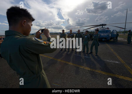 Les avions de l'Armée de l'air philippine de l'équipage prendre une photo à côté d'une U.S. Air Force HH-60G Pave Hawk dans le cadre d'un échange bilatéral au cours de l'exercice Balikatan 2015 à la Clark Air Base, Philippines, le 22 avril. L'échange de services américain a donné aux membres la possibilité d'interagir avec les membres du PAF et renforcer l'unité de l'US small-Philippine relations leader. (U.S. Photo de l'Armée de l'air par le sergent. Maeson L. Elleman) Banque D'Images