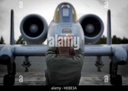 Un chef de l'équipe de guides un pilote, un parking A-10C Thunderbolt II à partir de la 107e Escadron de chasse à la base aérienne de Lielvarde Lettonie, 11 juin 2016. Forces armées des États-Unis et de la Lettonie, des aviateurs canadiens participeront à la grève 16 Sabre ; une longue, chefs d'état-major des Etats-Unis vers l'Europe, de l'armée américaine a conduit à l'exercice de formation coopérative, qui a été menée chaque année depuis 2010. L'exercice de cette année mettra l'accent sur la promotion de l'interopérabilité avec les alliés et partenaires régionaux. Les États-Unis ont des intérêts durables en faveur de la paix et la prospérité en Europe et à soutenir la force et la vitalité de l'OTAN, wh Banque D'Images