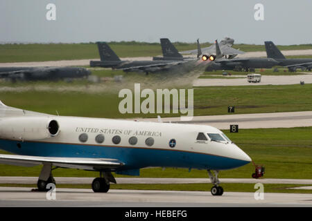 Un Gulfstream américain taxis tandis qu'un F-15C Eagle décolle pendant Valiant Shield en 2014. Valiant Shield est un exercice que l'intégration de la Marine américaine, l'armée de l'air, de l'Armée de terre et Marine Corps actifs, offrant des opérations conjointes d'expérience pour développer des capacités qui fournissent une gamme complète d'options pour défendre les intérêts des États-Unis et ceux de ses alliés et partenaires. (U.S. Photo de l'Armée de l'air par le sergent. William Banton/libérés) Banque D'Images