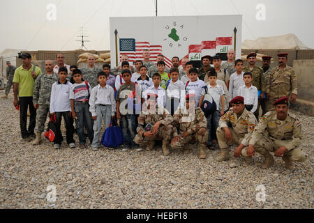 Des soldats irakiens et Américains posent pour une photo avec les élèves de l'école primaire Al Ezdehar le 22 mai, la station de Sécurité commune (2), Al Ezdahar Shayk Sa'ad, l'Iraq. Banque D'Images