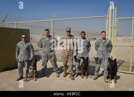 Clebe McClary, ancien premier lieutenant Marine qui a été blessé durant la guerre du Vietnam, pose pour une photo de groupe avec les chiens de travail et de leurs maîtres du 379e Escadron des Forces de sécurité de l'expéditionnaire à Al Udeid Air Base, au Qatar, le 15 janvier 2104. McClary partagé son histoire avec des aviateurs, des marins, marines, soldats et civils sur survivre plus de 40 chirurgies et surmonter le stress mental et émotif de perdre un oeil et le bras gauche. Aujourd'hui, McClary voyages à travers le monde et partage son histoire avec les hommes et les femmes de tous les âges. (U.S. Air Force photo/Senior Airman Jared Trimarchi) Banque D'Images