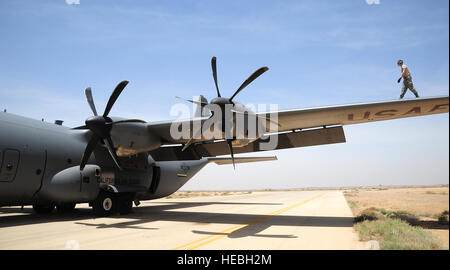 Les cadres supérieurs de l'US Air Force Airman Beau Lewis, chef d'équipe avec le 146e Escadron de maintenance des aéronefs à Channel Islands Air National Guard Station, Californie, les promenades le long de l'aile d'un C-130J Hercules pendant l'exercice lion avide 29 mai 2014, à une base aérienne dans le nord de la Jordanie. Au cours désireux de Lion, le C-130 a ajouté une autre dimension à des scénarios d'exercice, qui comprend la fourniture de l'aide humanitaire et secours en cas de catastrophe. (U.S. Photo de l'Armée de l'air par le sergent. Brigitte N. Brantley/libérés) Banque D'Images