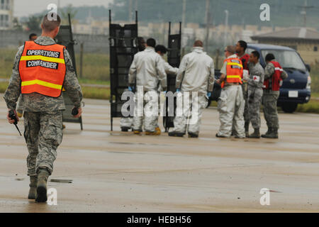 Les pompiers du 8e Escadron de génie civil et le personnel médical de la 8e groupe médical de coordonner les uns avec les autres au cours d'un exercice d'intervention en cas d'accident grave à Kunsan Air Base, République de Corée, le 29 septembre, 2011. Le loup PackÕs les premiers intervenants pratiqué leur réponse à une simulation d'écrasement d'avion pour s'assurer que la base est prête à répondre rapidement à toute situation réelle. (U.S. Photo de l'Armée de l'air par la Haute Bretagne Airman Y. Bateman/libérés) Banque D'Images