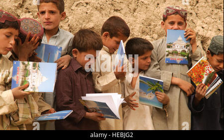 Les enfants afghans regardent leurs nouveaux portables lors d'une shura près de la base d'opération avancée Bullard, Shah Joy District, province de Zabul, Septembre 14, 2010. En plus des fournitures scolaires, le gouvernement de l'Afghanistan et de l'Équipe de reconstruction provinciale Zabul livré des fournitures pour la construction de deux puits dans le village. Banque D'Images