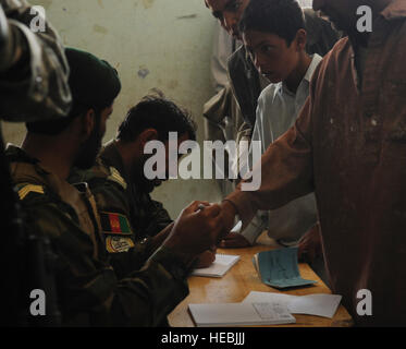 Des soldats afghans stamp patients mains à l'entrée d'une école dans le district de Zormat Paktya, province de l'Afghanistan où un programme de Rayonnement médical a eu lieu, le 18 mai. Santé de l'armée nationale afghane, les soldats de la 203e 'Thunder', Corps et base avancée Lightning/Thunder's Medical Embedded Training Team a ouvert une clinique gratuite et traité plus de 350 sections locales, pourvu plus de 400 ordonnances et a donné 140 immunisations à enfants de l'arrondissement. Banque D'Images