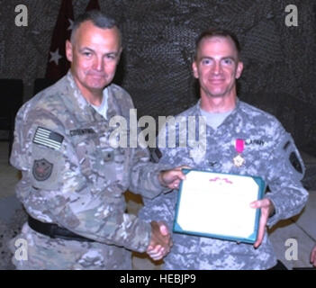 (À GAUCHE) Brig. Le Général Tom Cosentino, commandant adjoint, Soutien régional de formation de l'OTAN, Mission-Afghanistan/Combinés Transition conjointe de la sécurité, présente la Légion du Mérite au Colonel Gregory Bain, commandant sortant de l'appui régional avant d'Command-South la SRC-Sud cérémonie de passation de commandement à Kandahar, Airflield, le 9 juillet, à Kandahar, en Afghanistan. Le colonel Richard Wilson supposé de RSC-Sud à la cérémonie. Banque D'Images