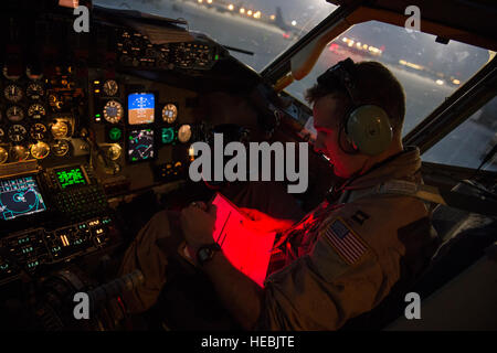 Le capitaine de l'US Air Force expéditionnaire Trent Parker, 340e Escadron de ravitaillement en vol KC-135 Stratotanker, pilote, lit une liste de pré-vol avant d'une mission de ravitaillement aérien sur l'Irak, le 12 août 2014. Comme le co-pilote pour la mission, Parker est chargé d'aider le commandant d'aéronef pour terminer la mission, décollages et atterrissages. L'équipage est prévu de débarquer plus de 40 000 gallons de carburant pour avions de remplir des missions en Iraq. (U.S. Photo de l'Armée de l'air par le sergent. Vernon Young Jr.) Banque D'Images