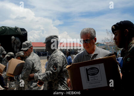 (De gauche) Task Force Bon Voizen soldats ; Mark Stansberry, de peuple à peuple le président du conseil d'administration international ; et d'un soldat de la Force de défense bélizienne aider à décharger des boîtes de fournitures scolaires 16 juin comme ils font des dons à l'Ecole Nationale de K. George, le premier de trois écoles de recevoir des dons d'aujourd'hui. Les gens entre eux et l'exploitation Internationale des Enfants International a fait don de 2 500 kits de fournitures scolaires, qui ont été distribuées aux enfants dans trois écoles différentes, qui étaient d'anciens projets de Nouveaux Horizons, dans le département d'Artibonite d'Haïti, le 16 juin 2011. Les fournitures étaient deli Banque D'Images