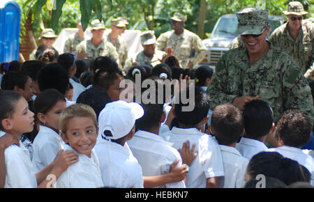 Maître de 3e classe Luis Vivas, du Bataillon de construction navale 23 Mobile, basé à Fort Belvoir en Virginie, accueille les étudiants en dehors de l'école, lui et ses collègues ont aidé à construire à Morales Seabees, le Honduras le 27 juin. Les Seabees construit l'école, ainsi qu'une clinique en Ociente à proximité, dans le cadre de l'Armée américaine du sud au-delà de l'horizon de l'exercice 2012. Banque D'Images