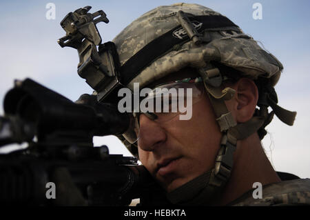 Le sergent de l'armée américaine. Jon capot, la101St Airborne Division, 3e Brigade Combat Team, 3e bataillon du 187e Régiment d'infanterie, fournit la sécurité à proximité d'un possible lieu de sépulture dans Qwesat, l'Iraq, le 18 décembre, comme les soldats de l'armée américaine et les chiens de recherche aide recherche le domaine de possible demeure ou les indices de la trace de la CPS. Alex Jimenez et Pvt. Fouty Byron, de la 10e division de montagne, qui tous deux ont enlevé le 12 mai 2007. Banque D'Images