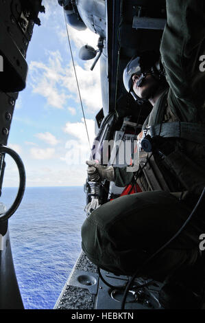 Maître de 2e classe Lucas Voie se prépare à descendre une ligne à un nageur de sauvetage dans l'eau ci-dessous lors de la formation de sauvetage sur l'eau le 25 avril 2013, près de la plage Sirena à Andersen Air Force Base, Guam. Voie est un escadron d'hélicoptères de combat de la mer 25 aircrewman. (U.S. Air Force photo/Navigant de première classe Mariah Haddenham) Banque D'Images