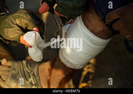 Les cadres supérieurs de l'US Air Force aérienne expéditionnaire, l'OEA Craig 455 e Escadron des Forces de sécurité, fournit une aide médicale à un garçon afghan local qui a été brûlé il y a plusieurs mois par un autre villageois afghans le 23 octobre 2012, à l'extérieur de l'aérodrome de Bagram, en Afghanistan. 455 E SESF ont des équipes régulièrement à l'extérieur de la 'patrouille' fil autour de la base à périmètre d'activités suspectes et visiter les villages locaux de renforcer les relations avec les habitants. La ville natale de l'OEA est Munising, au Michigan (É.-U. Air Force photo/ Le s.. Jonathan Snyder)(1992) Banque D'Images