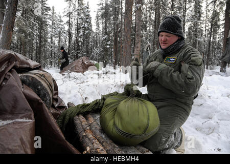 U.S Air Force Staff Sgt. Vance Streeter, 210e Escadron de sauvetage aerial gunner, construit un bouchon de porte pour son abri le 21 février 2013, Eielson Air Force Base, en Alaska. Le bouchon, quand bien mis, empêche le froid de pénétrer dans l'abri et peuvent aider à garder la chaleur interne à un niveau bien au-dessus de la température extérieure. (U.S. Air Force Photo/Peter Reft Navigant de première classe) Banque D'Images