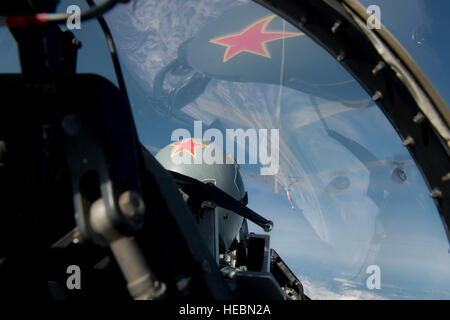 Le casque du U.S. Air Force Le Capitaine Todd Possemato, un 18e escadron agresseur, pilote de l'auvent se reflète sur d'un F-16 Fighting Falcon que la rampe d'un KC-135 Stratotanker s'étend pour faire le plein de l'avion de chasse le 4 mai 2015, au cours de Red Flag Alaska. La star de l'unité et jaune la faucille et marteau symbolise l'Union soviétique, l'ennemi pendant la guerre froide. Aujourd'hui, le 18 AGRS répliquer menaces rencontrées par les forces aériennes de combat plutôt qu'un adversaire spécifique. Le F-16 est affecté à la 354e Escadre de chasse, Eielson Air Force Base, l'Alaska, et le Stratotanker est déployée pour l'exerc Banque D'Images