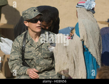 Le lieutenant-colonel (Dr.) Thomas Knolmayer donne et fille afghane de chaussures à une visite d'assistance humanitaire. Les vêtements, chaussures, manteaux et couvertures mis dans le camp de réfugiés étaient des dons faits à l'opération soins par les citoyens américains. La Kapisa et Pawarn l'Équipe provinciale de reconstruction a travaillé avec le Ministère afghan des réfugiés et à réparation pour coordonner l'aide humanitaire. Le Camp de Réfugiés de Parwan est le foyer de certains des pays les plus pauvres de l'Afghanistan. Banque D'Images