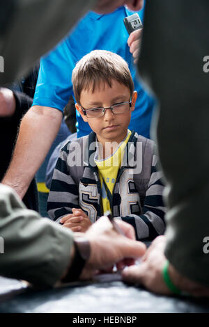 Un garçon attend que sa photo d'un B-52 d'être signé par un membre de l'équipage 93e Bomb Squadron slovaque au cours de l'International Air Fest, le 1 septembre 2012, Sliac, la Slovaquie. La 93e BS, affecté à la 307e Bomb Wing, Base aérienne de Barksdale, en Louisiane, a appuyé l'air show avec du personnel et un B-52H Stratofortress. (U.S. Air Force photo par le Sgt. Greg Steele/libérés) Banque D'Images