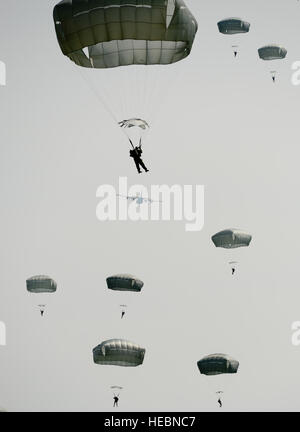 Les parachutistes de descendre lentement vers le sol comme un C-130 vole au loin dans la distance pendant la semaine de Saut International le 5 mai 2014, à l'Alzey zone d'atterrissage, de l'Allemagne. Plus de 300 cavaliers provenant de neuf pays différents a effectué 404 sauts en ligne à l'électricité statique et à faible altitude 132 sauts d'ouverture en trois jours. (U.S. Air Force photo/un membre de 1re classe Michael Stuart) Banque D'Images