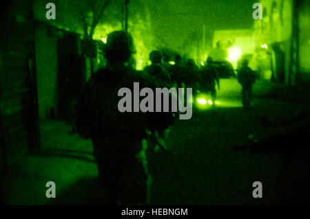 Des soldats américains suivent derrière Ghazaliyah police patrouille comme ils distribuent des brochures d'information pour les citoyens irakiens dans Muhalla 673 de Ghazaliyah, Iraq le 4 septembre 2008. Les soldats américains font partie du 4e peloton, Compagnie Bravo, 1er Escadron, 75e de cavalerie, 101e Division aéroportée. Banque D'Images