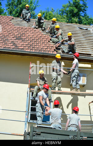 (Troisième soldat du bas) PFC. Tomala Nathan et d'autres soldats d'argile de recyclage des bardeaux sur un toit d'un centre communautaire local en Croatie, le 22 juin 2015. La FPC. Tomala est avec la 851ème compagnie du génie Vertical au Camp Ripley Training Centre, au Minnesota, le Bureau de l'Office de coopération en matière de défense et d'aide humanitaire Programme d'aide municipale du travail fourni, les fournitures pour les soldats de la Garde nationale du Minnesota et de l'armée de Croatie à la réalisation du projet. Banque D'Images