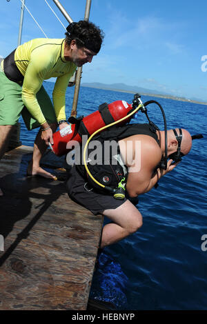 John Thompson, président de l'engagement des soldats de l'armée à la retraite aide Plongée handicapés Le s.. Thomas Davis entre dans l'eau à la base navale de Guantanamo Bay, le 27 août, 2010. Davis est venu à la base avec les SUDS pour obtenir une certification de plongée en eau libre. Les bénévoles de la station navale de Guantanamo Bay et de la Force opérationnelle interarmées Guantanamo accueilli DUU participants 26-31 août. Banque D'Images