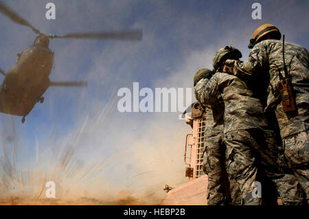 Les aviateurs de l'US Air Force à partir de la 820e Airborne Cheval Rouge vol, attendez que le Nevada Army National Guard 1er bataillon du 189e compagnie aérienne hélicoptère CH-47 Chinook à ramasser une élingue d'équipement lourd-charge à Nellis Air Force Base, Nevada, 23 juillet 2011. Les membres de la Garde nationale du Nevada et de l'ERS 820 vol aéroportée formés ensemble pour améliorer leur interopérabilité tout en menant des gouttes de l'air et de l'élingue-les opérations de chargement. (U.S. Photo de l'Armée de l'air par le sergent. Larry E. Reid Jr./libérés) Banque D'Images