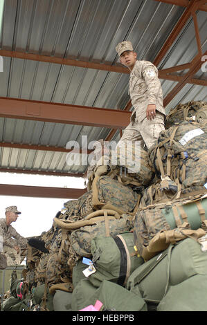 Lance le Cpl. Lawrence C. Contreras stacks sacs de voyage et sacs à dos haut à l'aérogare des passagers de la Base aérienne de Manas, au Kirghizistan, le 27 avril. Contreras, un technicien de support de l'eau avec le 8e Bataillon de soutien du génie à Camp Lejeune, N.C. et est originaire de San Jose, CA. 'Être dans l'armée est une expérience qui change la vie ; un vrai bond entre frères,' dit Contreras. Banque D'Images