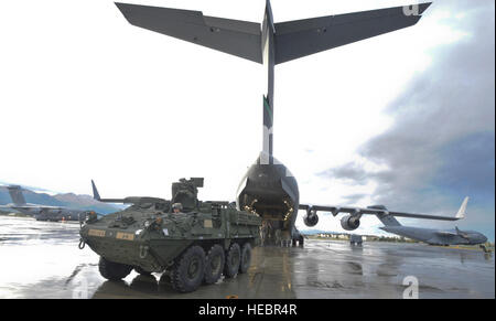 Des soldats de l'armée américaine Alaska's 1st Stryker Brigade Combat Team, 3e Bataillon du 21e Régiment d'infanterie, hors charge de la U.S. Air Force C-17 Globemaster III sur la piste à Joint Base Elmendorf-Richardson, Alaska, le 10 septembre 2013, comme deux C-17 chargé avec affectés à des parachutistes 1er Escadron (Airborne) 40e Régiment de cavalerie taxi sur la piste pour une mission de formation de l'aérolargage connexes. Les soldats transportés avec leur Strykers de Fort Wainwright, Alaska, à participer à un exercice d'entraînement de combat avec USARAK's 4th Infantry Brigade Combat Team à JBER. (U.S. Air Force ph Banque D'Images