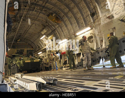 Soldats affectés au 3e Bataillon, 21e Régiment d'infanterie, une partie de l'armée américaine Alaska's 1st Stryker Brigade Combat Team, 25e Division d'infanterie, attendez de décharger un Stryker de l'US Air Force à partir d'un C-17 Globemaster III sur la ligne de vol à Joint Base Elmendorf-Richardson, Alaska, le 10 septembre, 2013. Les soldats transportés avec leur Strykers de Fort Wainwright, Alaska, à participer à un exercice d'entraînement de combat avec USARAK's 4th Infantry Brigade Combat Team (Airborne), 25e Division d'infanterie, à JBER. (U.S. Air Force Photo de Justin/Connaher) Parution Banque D'Images